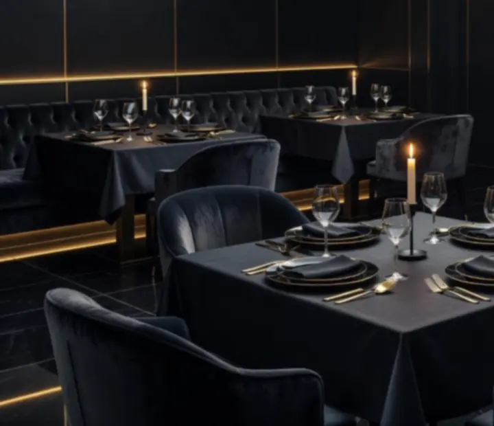 Večerní atmosféra restaurace s tlumeným světlem, svíčkami a elegantně prostřenými stoly.