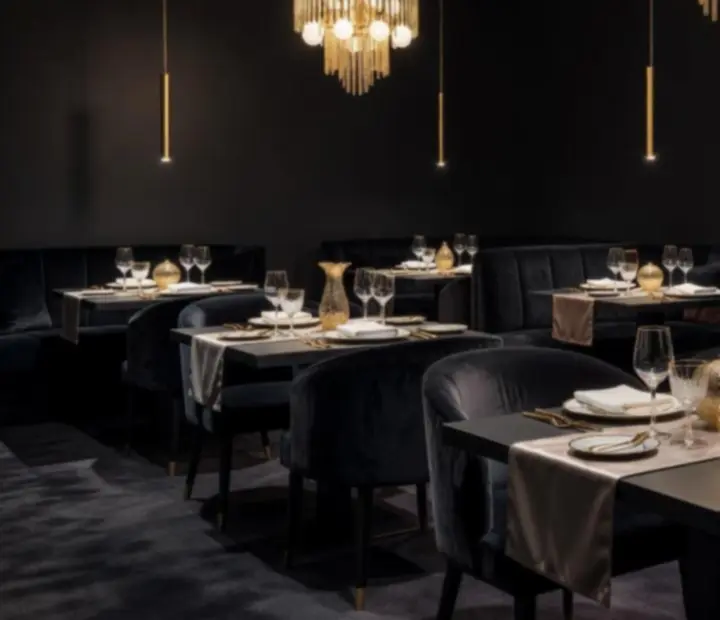 Luxusní interiér restaurace s tmavými tóny a zlatými detaily