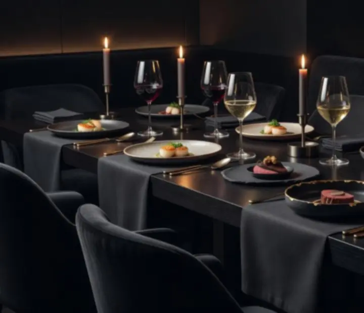 Degustační menu večera naservírované na elegantně prostřeném stole s večerním nasvícením.